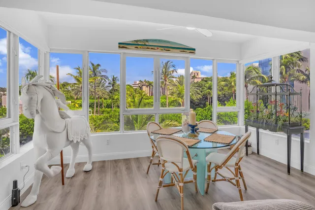 a dining room with furniture water view and a floor to ceiling window
