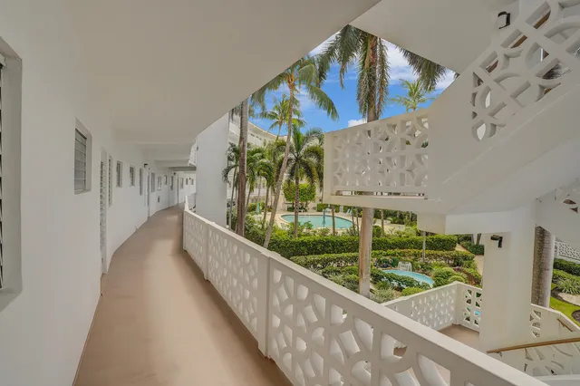 a view of a pathway both side of grassy field with shrub