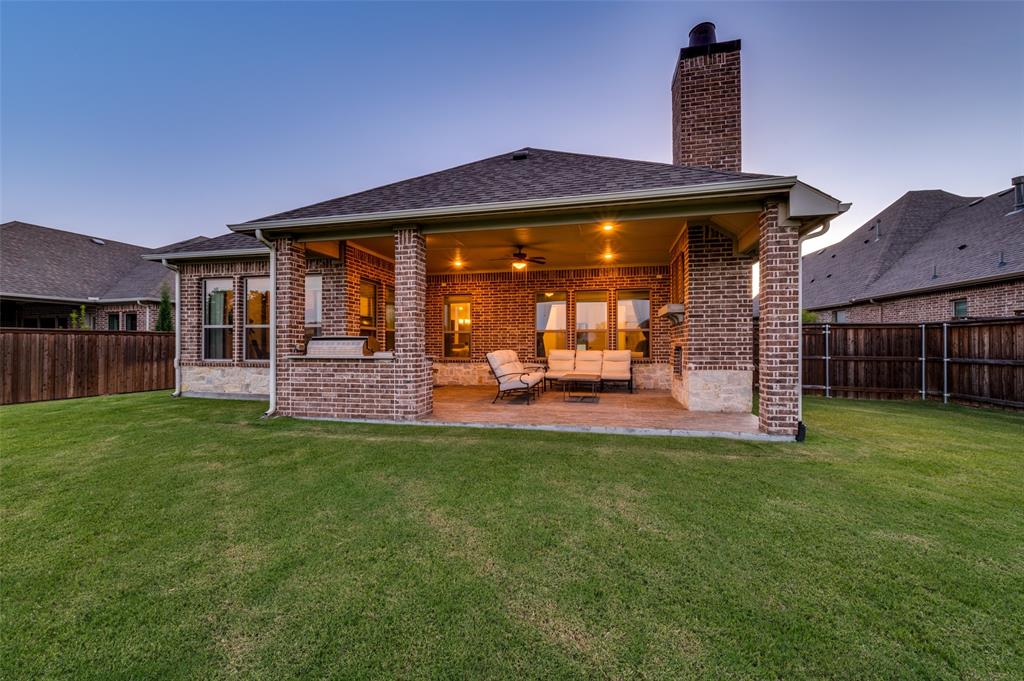 7821 Kentmere The Colony, TX 75056 - Photo 24 of 40 The ultimate outdoor entertaining space features an oversized covered patio complete with a built-in grill, griddle, outdoor fireplace, and ceiling fan for year-round enjoyment. Overlooking the expansive quarter-acre backyard and tranquil canal, this exceptional outdoor living area is designed for unforgettable gatherings and everyday relaxation.