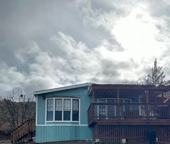 a view of a house with wooden fence and roof