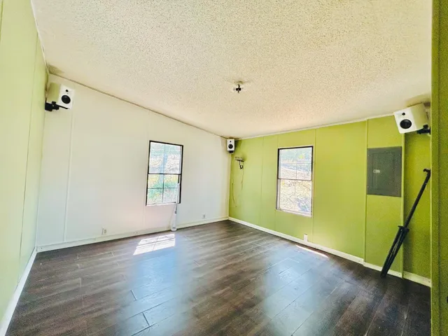 an empty room with wooden floor and windows