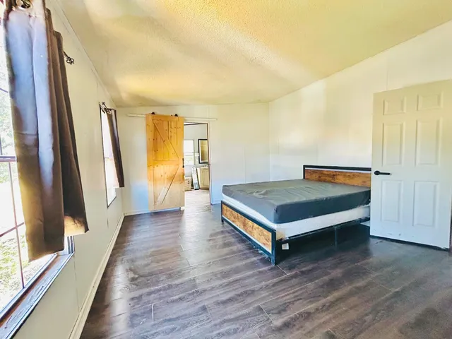 a bedroom with a bed and wooden floor