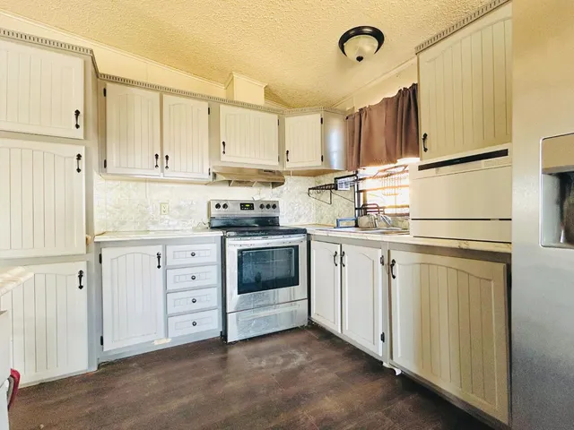 a kitchen with white cabinets and white appliances