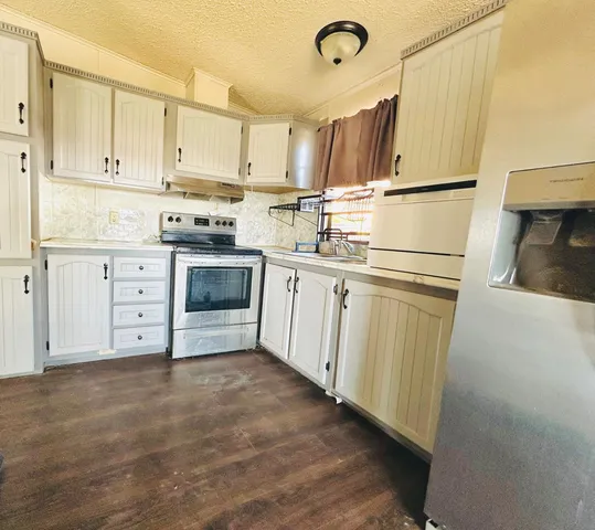 a kitchen with white cabinets and white appliances
