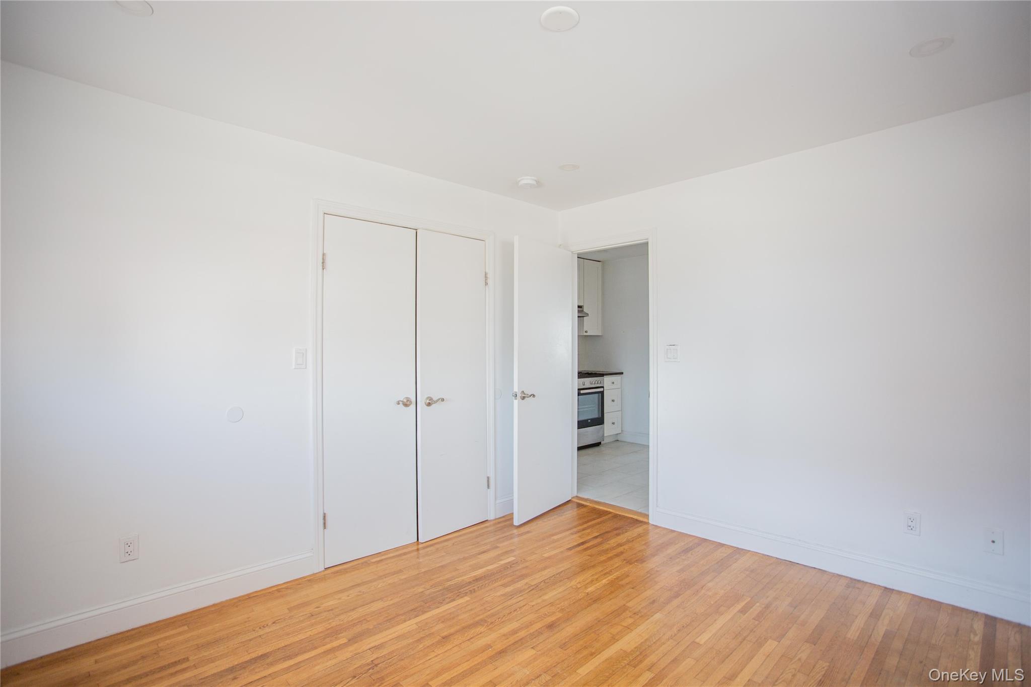 340 East Broadway, Unit 112 Long Beach, NY 11561 - Photo 13 of 19 a view of empty room with wooden floor