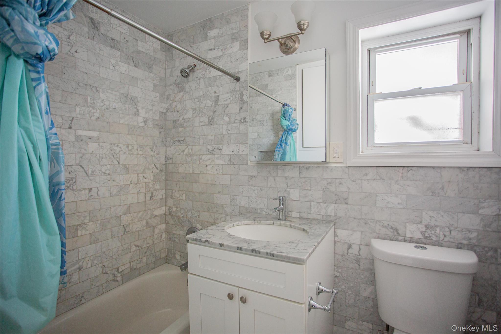 340 East Broadway, Unit 112 Long Beach, NY 11561 - Photo 14 of 19 a bathroom with a granite countertop sink a toilet and shower