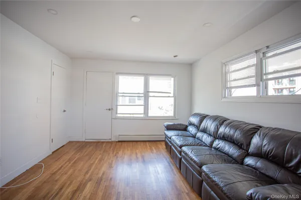 a living room with a couch wooden floor and a window