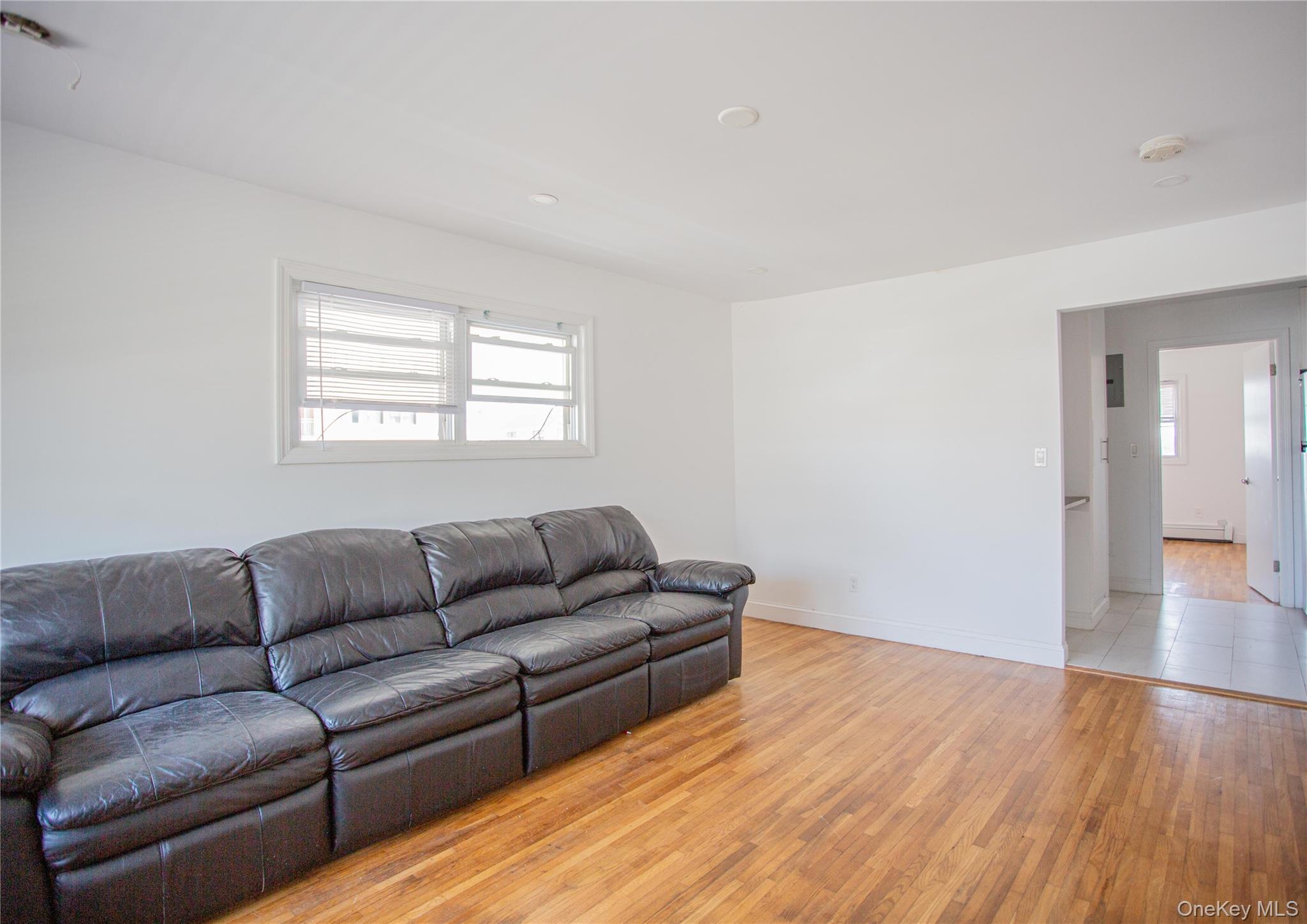 340 East Broadway, Unit 112 Long Beach, NY 11561 - Photo 6 of 19 a living room with furniture and a wooden floor