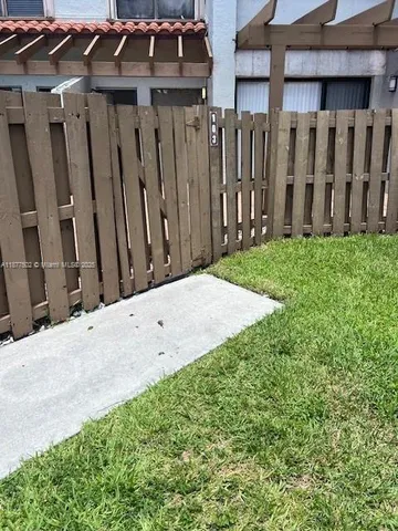 a view of a backyard with wooden fence