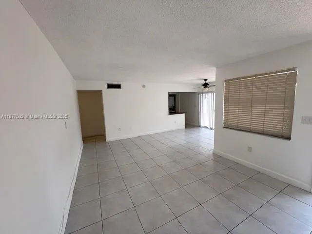 a view of a livingroom with an empty space and a window