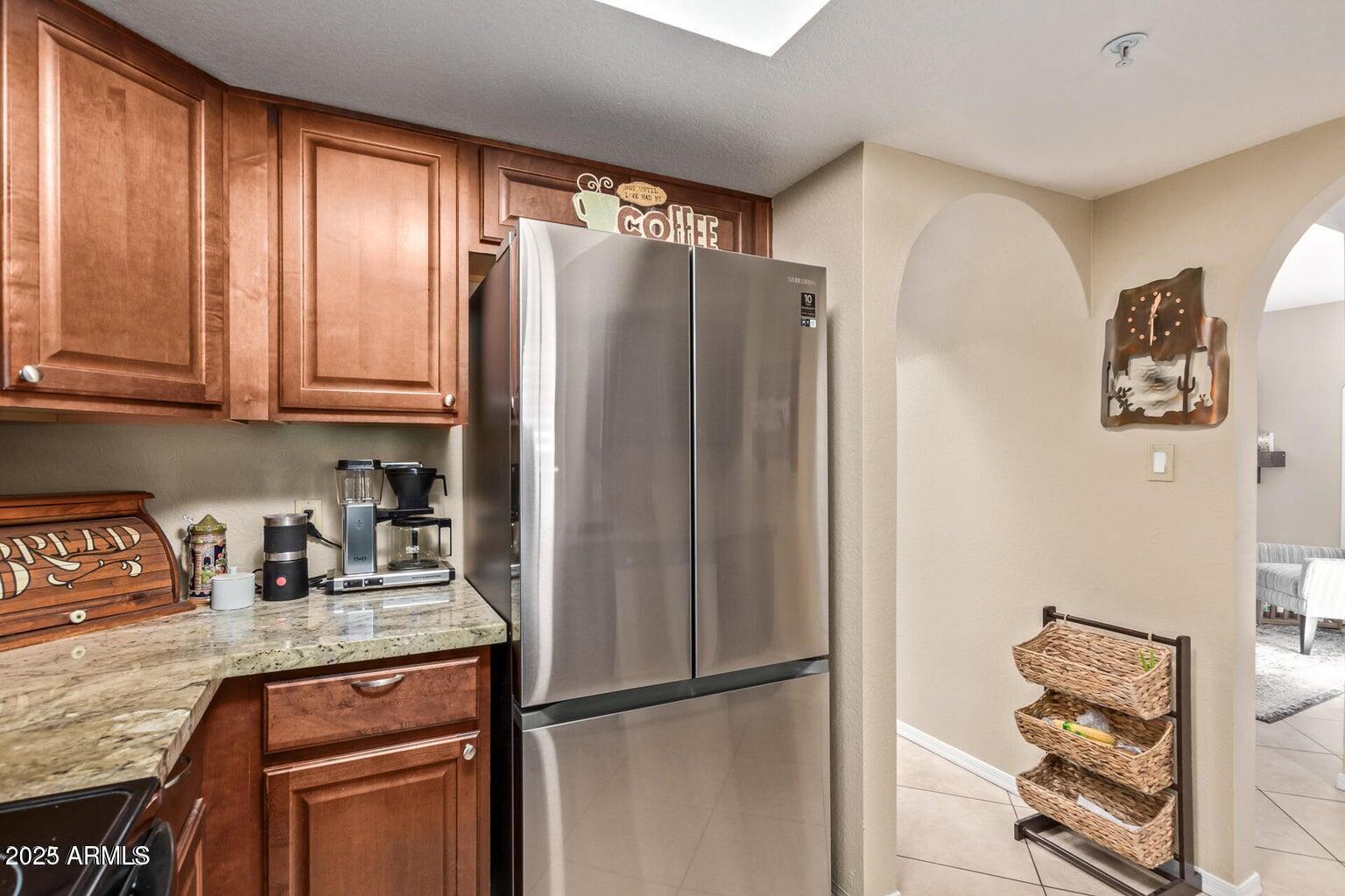 6945 East Cochise Road, Unit 130 Paradise Valley, AZ 85253 - Photo 11 of 24 a kitchen with stainless steel appliances granite countertop a refrigerator and a stove top oven