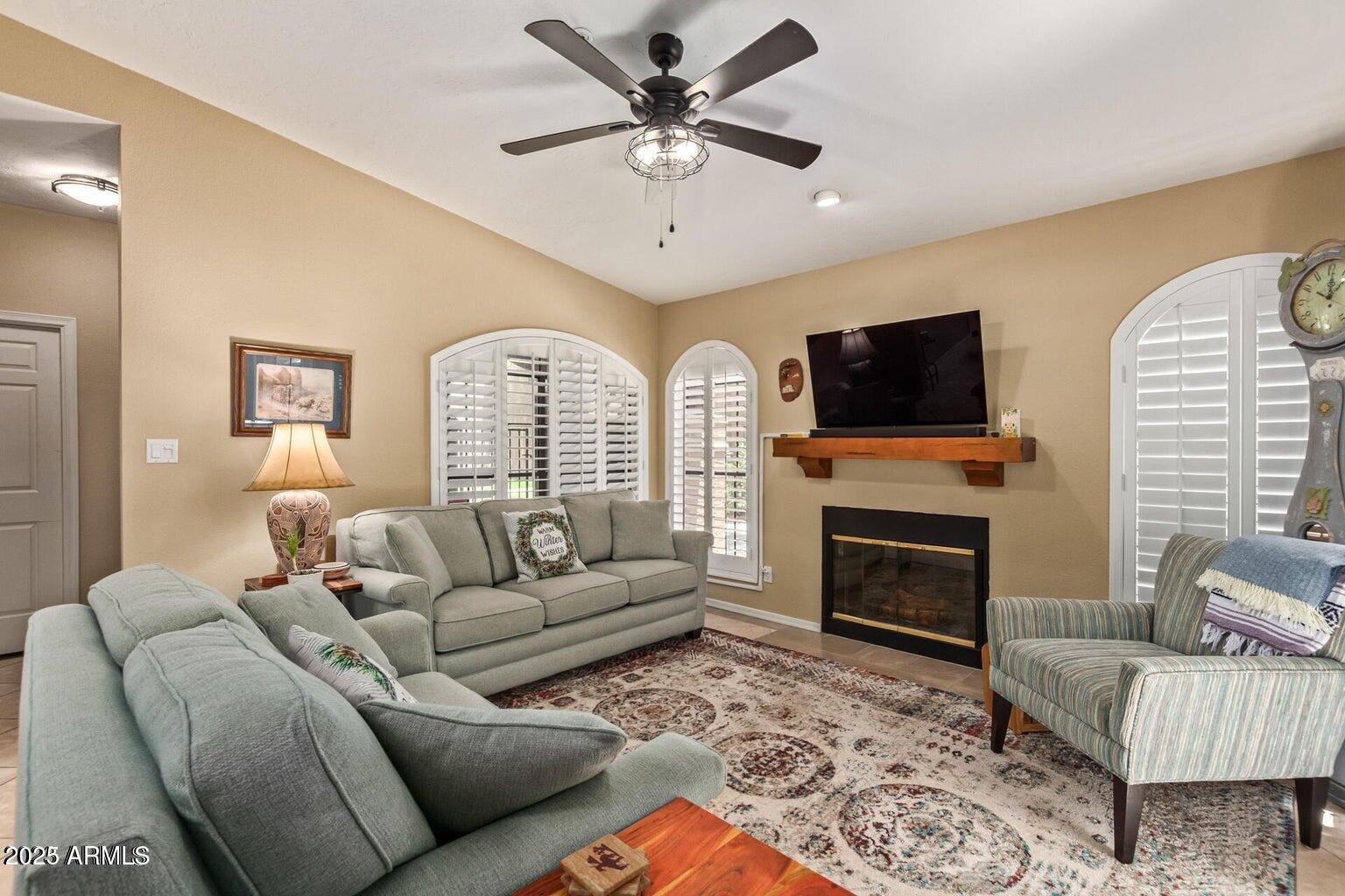6945 East Cochise Road, Unit 130 Paradise Valley, AZ 85253 - Photo 6 of 24 a living room with furniture a fireplace and a flat screen tv