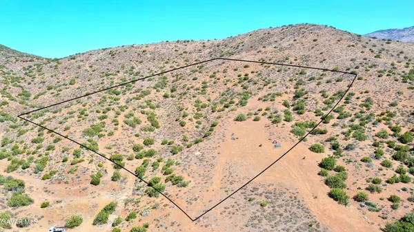 a view of a dry yard with an umbrella