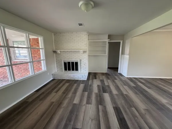wooden floor in an empty room with a fireplace