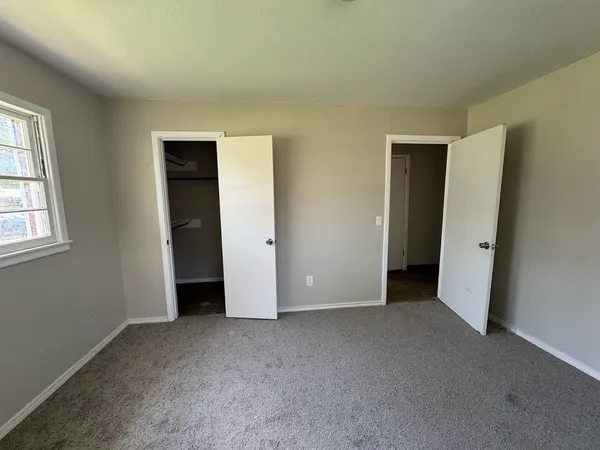 an empty room with windows and closet