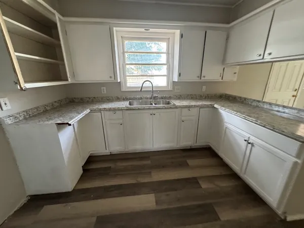 a kitchen with granite countertop a sink and a stove
