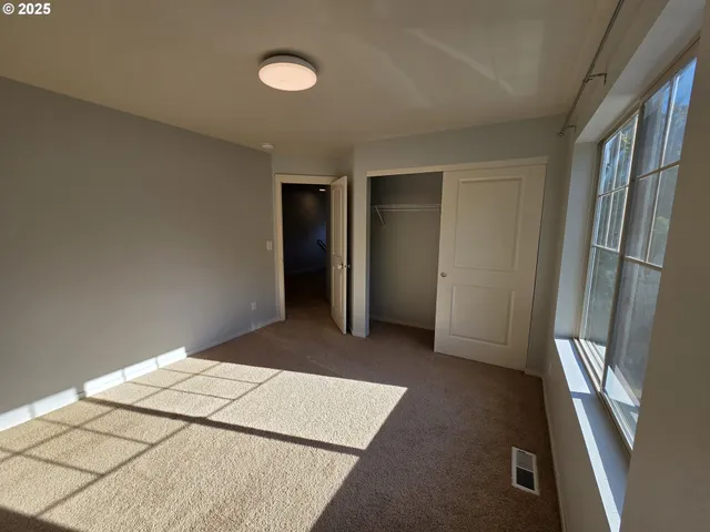 an empty room with windows and closet