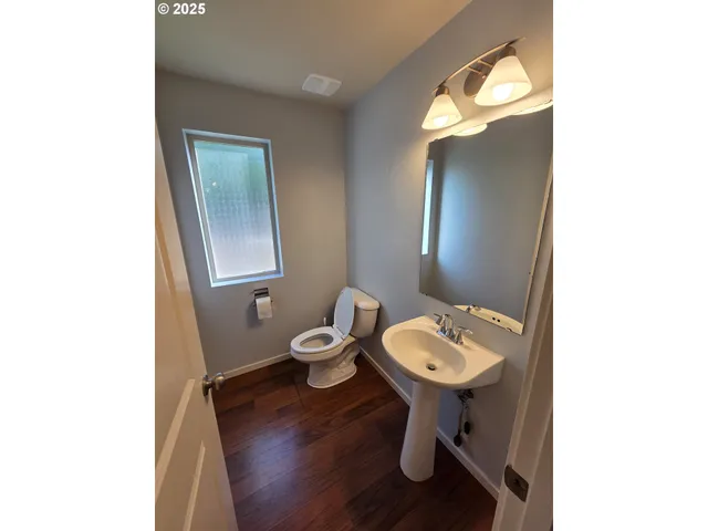 a bathroom with a toilet a sink and mirror