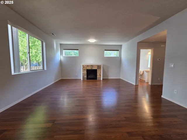 a view of a livingroom with wooden floor and a window