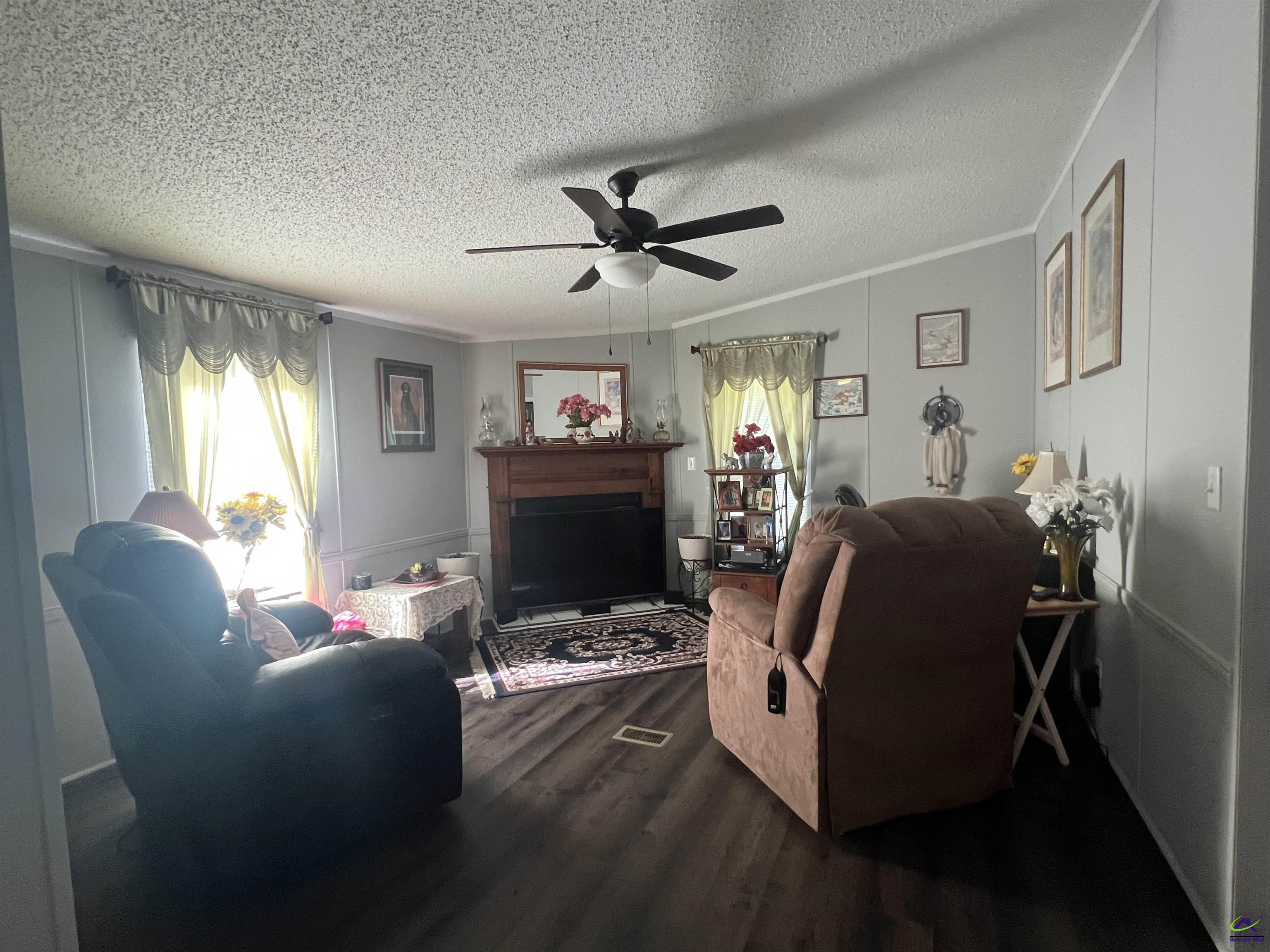 166 Pebble Hills Road Cochran, GA 31014 - Photo 17 of 27 a living room with furniture a fireplace and a flat screen tv