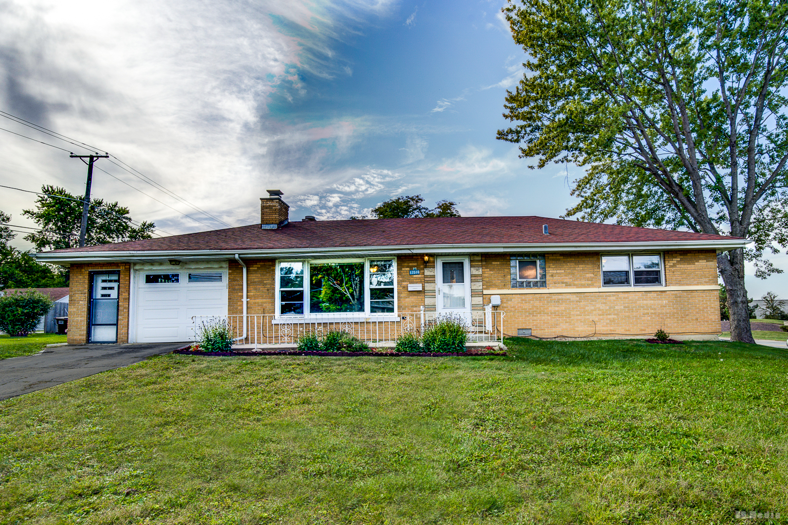 a front view of a house with a yard and trees