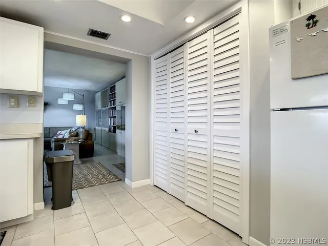a view of a hallway with kitchen and entryway