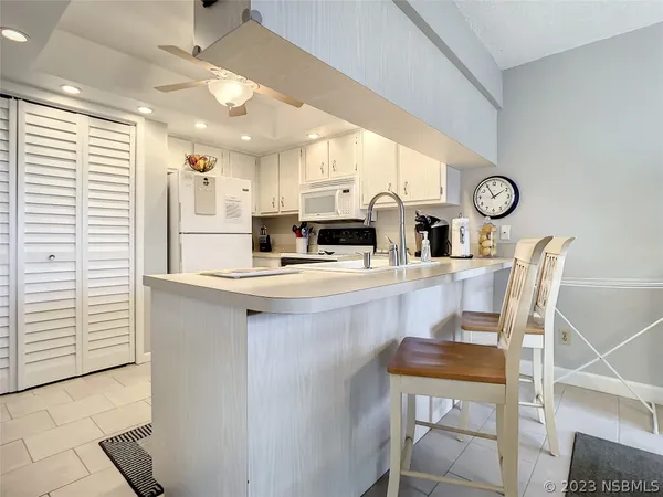a kitchen with a table chairs refrigerator and cabinets