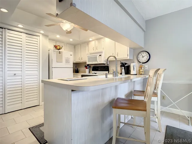 a kitchen with a table chairs refrigerator and cabinets