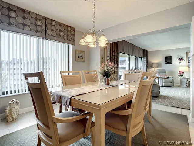 a dining room with furniture a chandelier and wooden floor