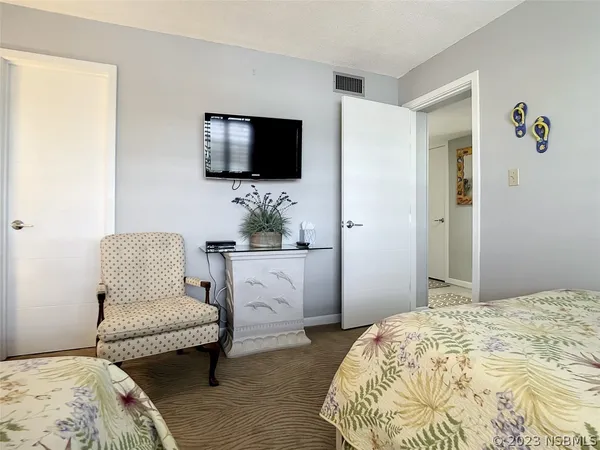 a bedroom with a bed and a flat screen tv