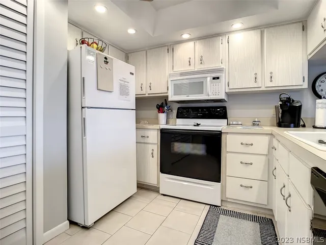 a kitchen with white cabinets and white appliances