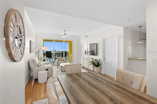 a living room with furniture a large window and a chandelier