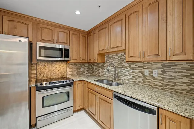 a kitchen with stainless steel appliances wooden cabinets and a stove top oven