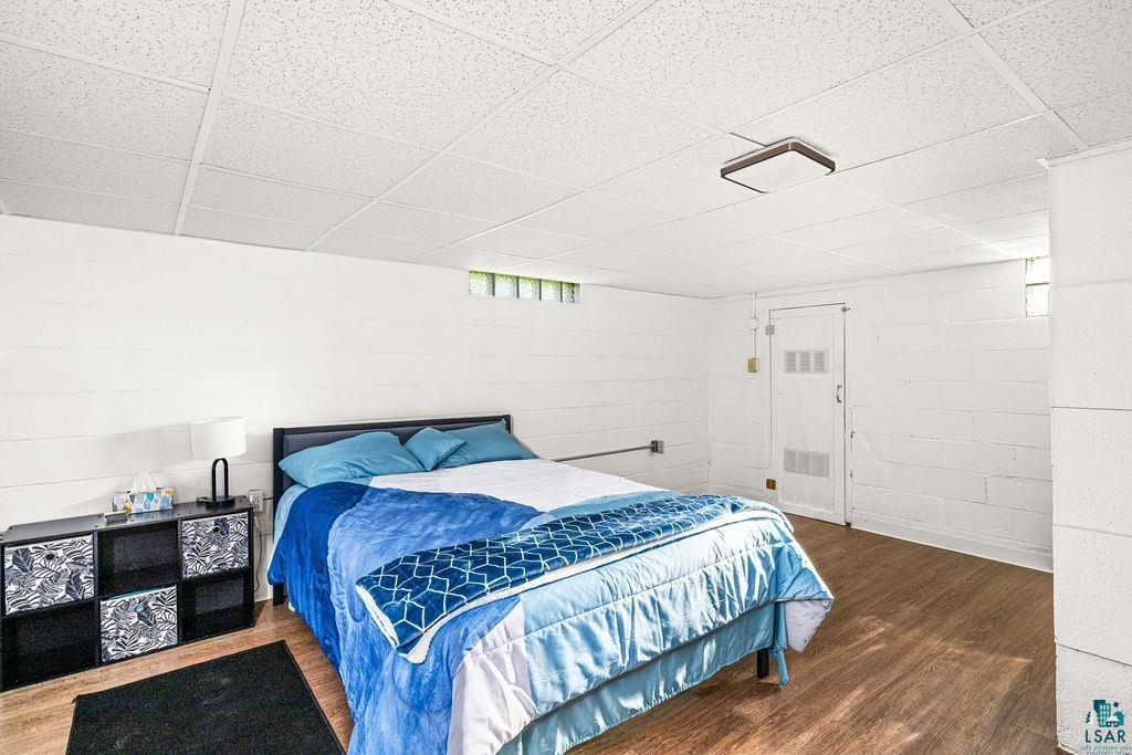 4543 County Road East South Range, WI 54874 - Photo 23 of 43 Room featuring wood-finish flooring, white shiplap walls, a drop ceiling, and a flush mount ceiling light