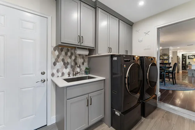 a kitchen with stainless steel appliances granite countertop a refrigerator a stove top oven a sink dishwasher and white cabinets with wooden floor