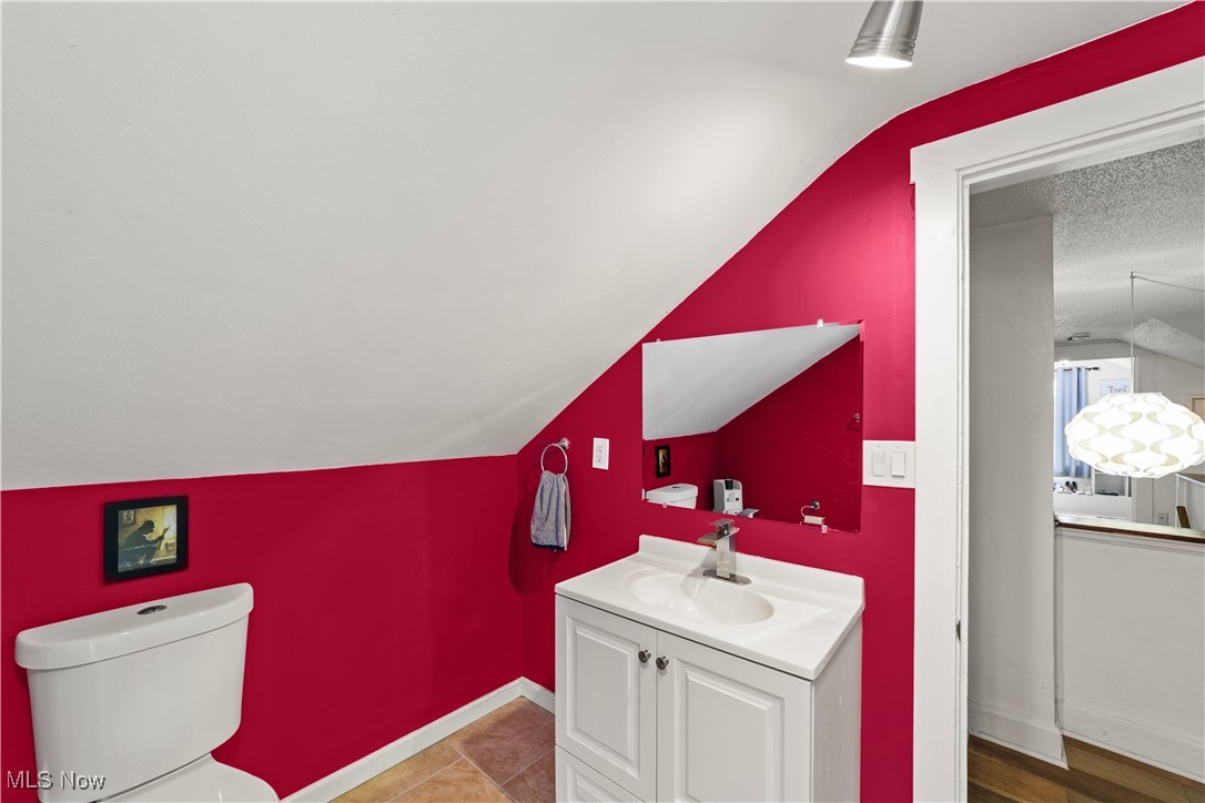 14420 Superior Road Cleveland, OH 44118 - Photo 34 of 44 Bathroom featuring vanity, lofted ceiling, toilet, and baseboards