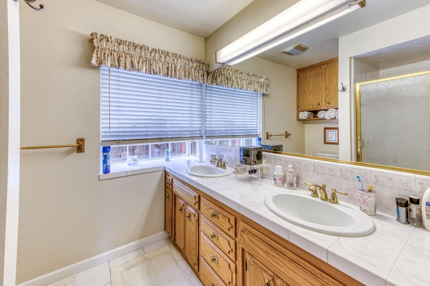 2367 Frederick Way Madera, CA 93637 - Photo 24 of 30 a bathroom with a sink a mirror and a shower