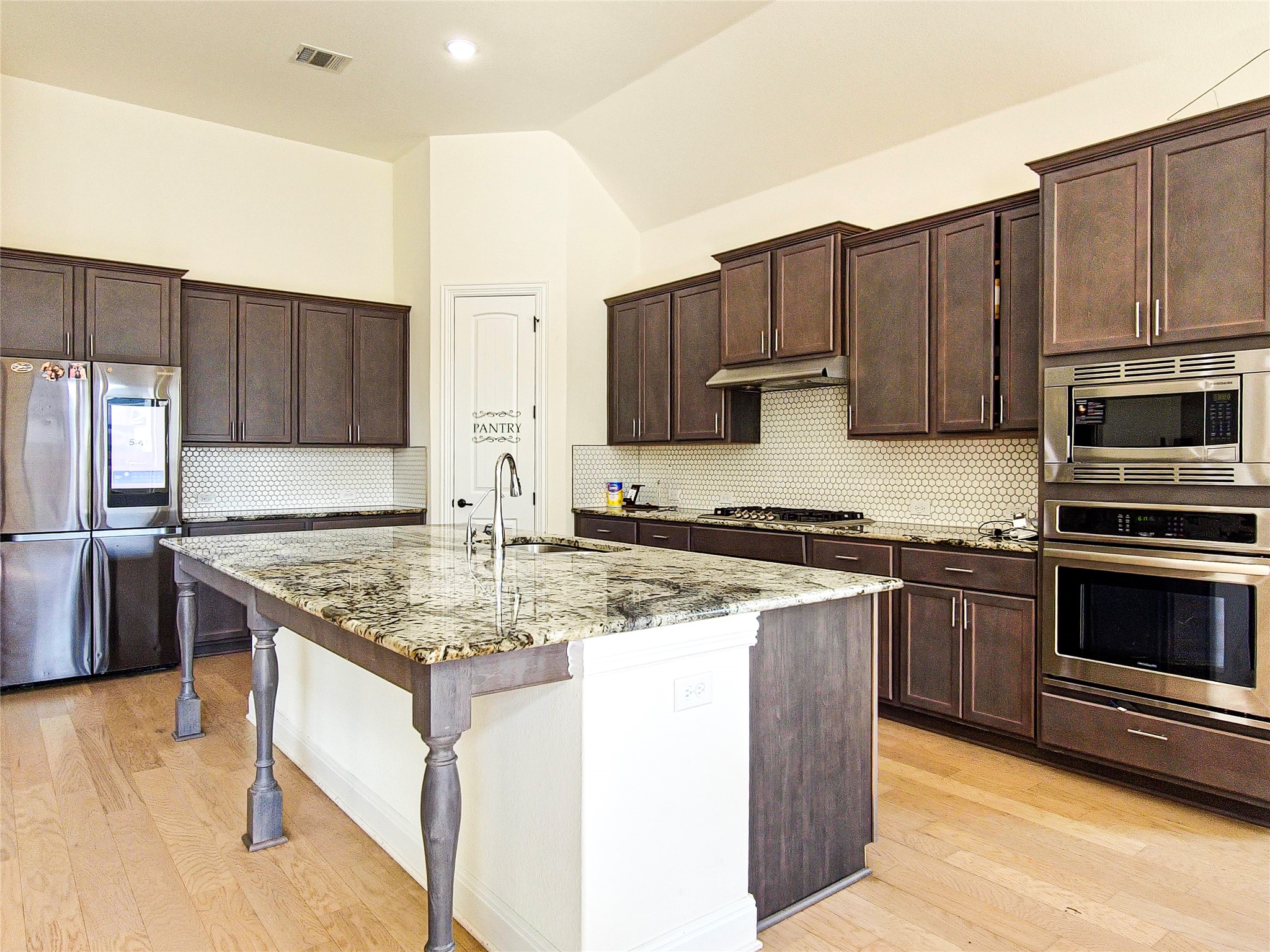 813 Sunny Ridge Drive Leander, TX 78641 - Photo 7 of 32 Culinary creations come to life in this spacious kitchen, featuring a generous island with seating.