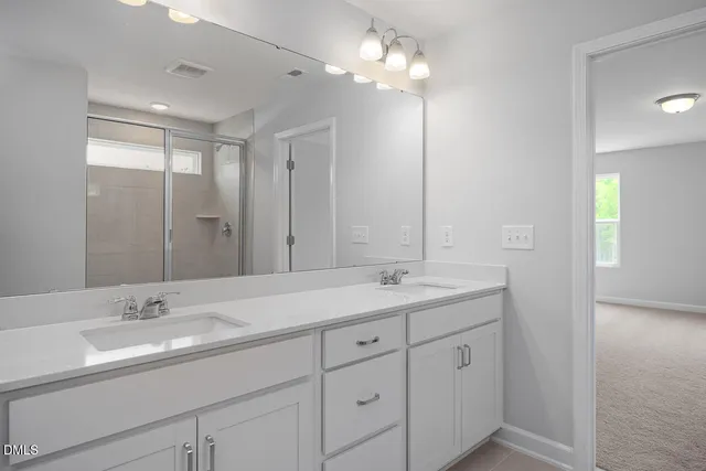 a bathroom with double sink and a mirror
