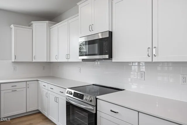 a kitchen with white cabinets and white appliances