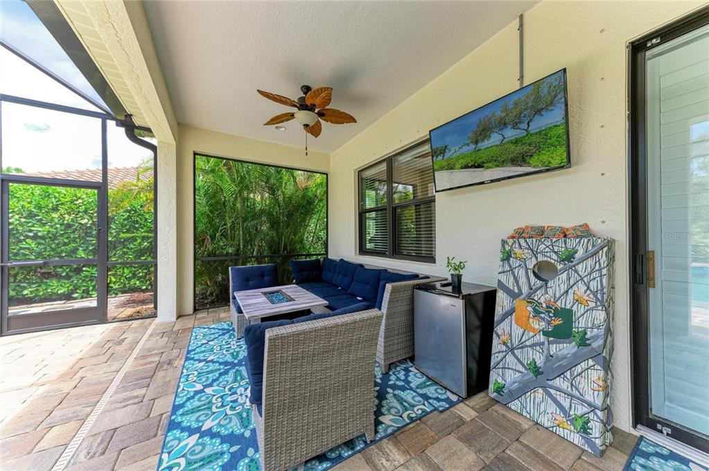 12642 Harney Street Venice, FL 34293 - Photo 49 of 85 a living room with furniture tv and a floor to ceiling window