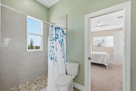 a spacious bedroom with a bed couch and window