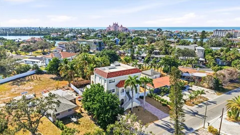 an aerial view of a city with lots of residential buildings ocean and mountain view in back