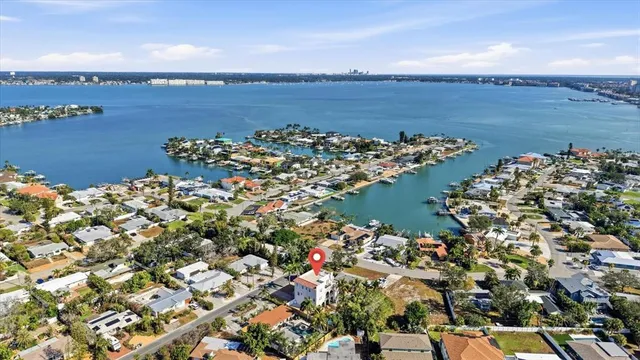 an aerial view of ocean and residential houses with outdoor space