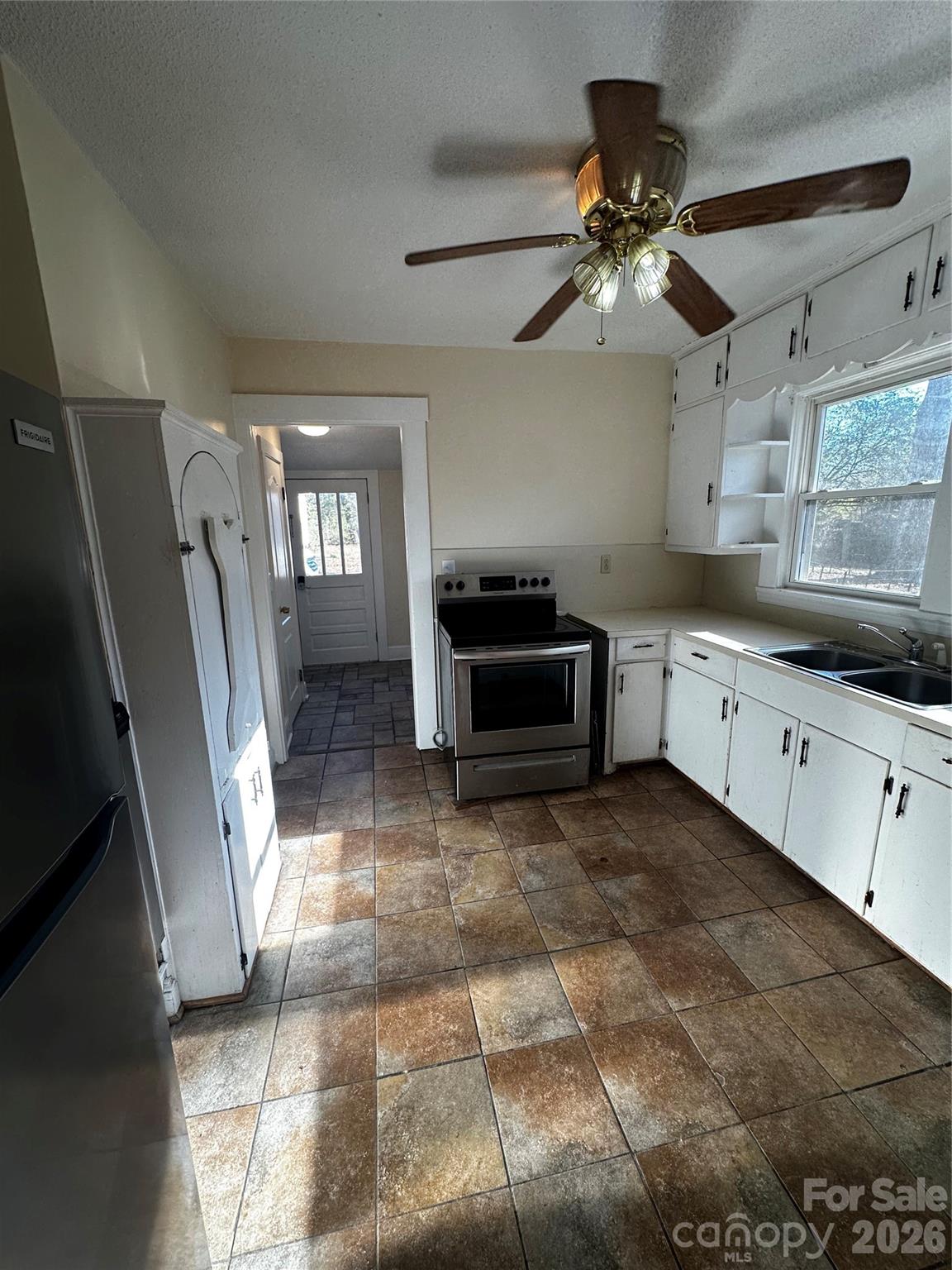 1803 West Main Street Albemarle, NC 28001 - Photo 6 of 13 a kitchen with granite countertop a refrigerator a sink a stove a dining table and chairs