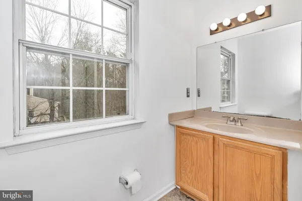 a bathroom with a granite countertop sink mirror and a window