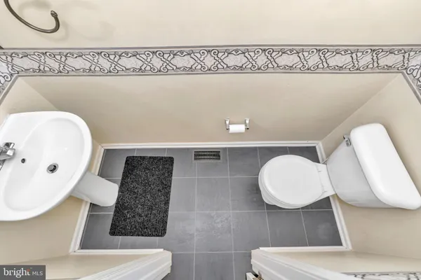 a bathroom with a toilet a sink and mirror