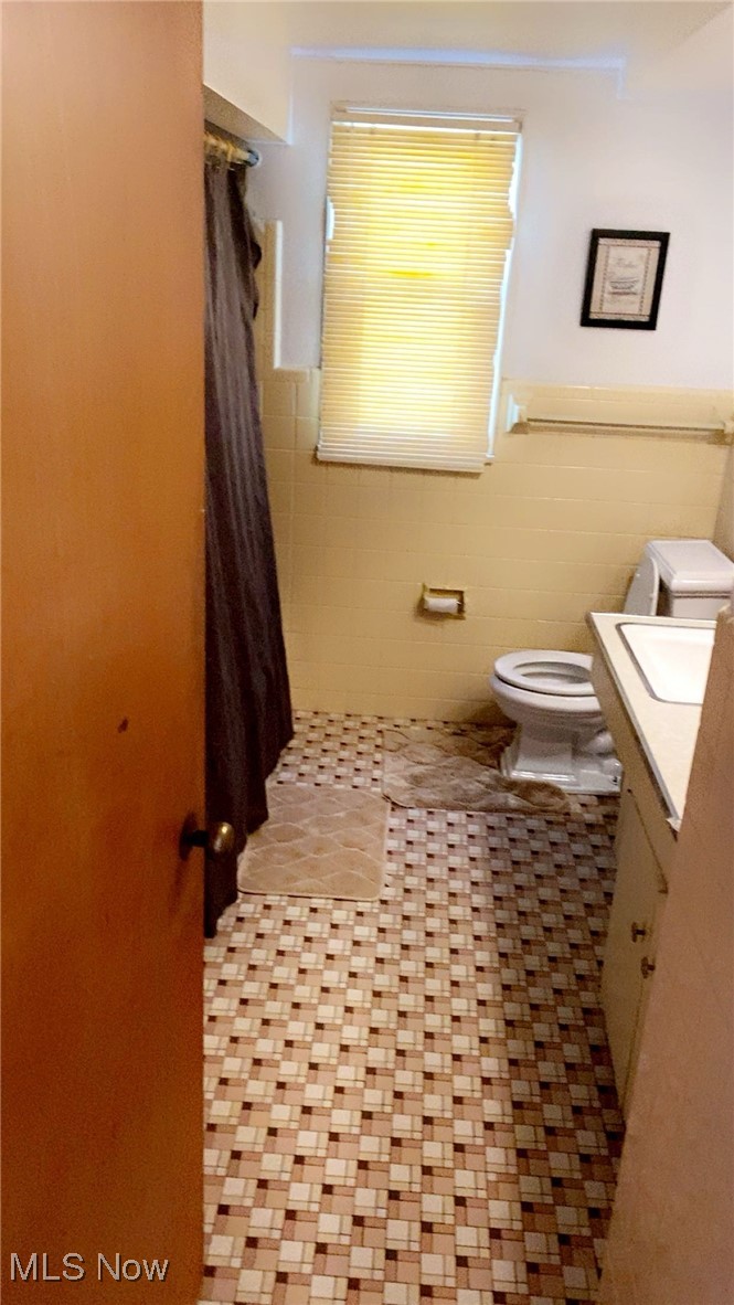 15657 Fenemore Road Cleveland, OH 44112 - Photo 19 of 26 Bathroom with tile walls, toilet, vanity, and tile patterned flooring