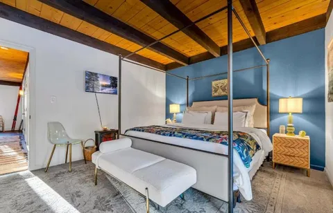 a bedroom with a bed and a lamp with the dresser