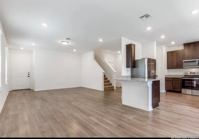 a view of kitchen with furniture and stainless steel appliances